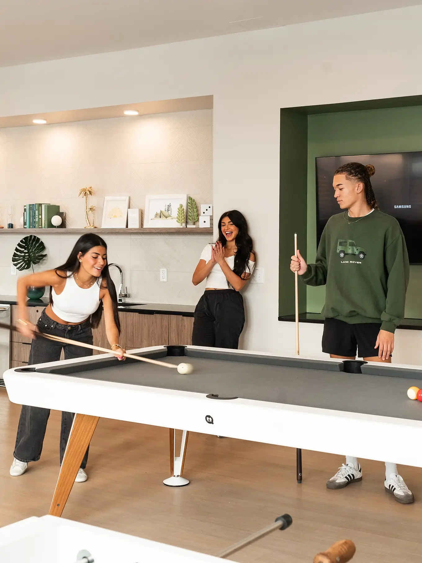 group of young adults playing pool