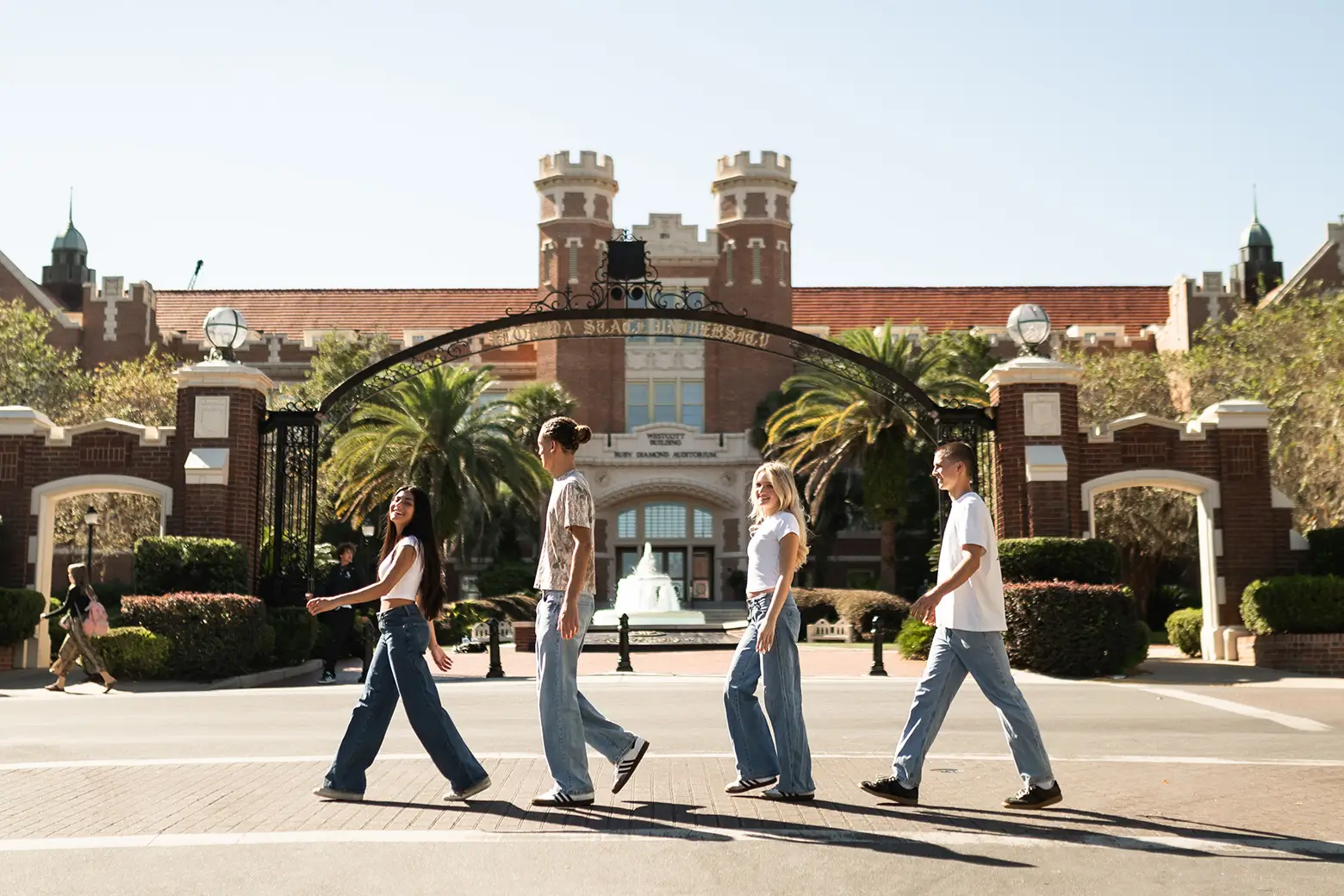 group of young adults walking across a street