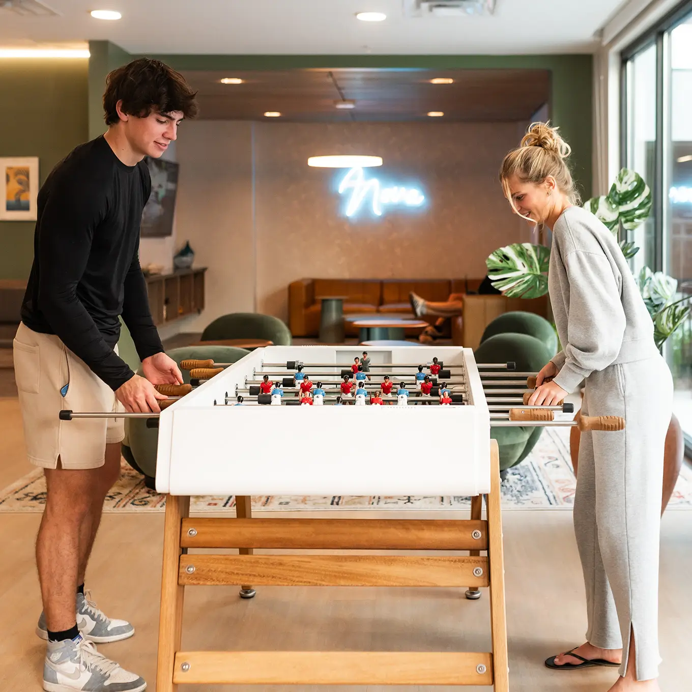 two young adults playing foosball
